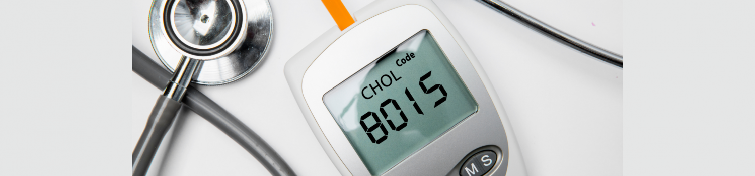 Closeup of medical device for measuring cholesterol and a stethoscope on a table