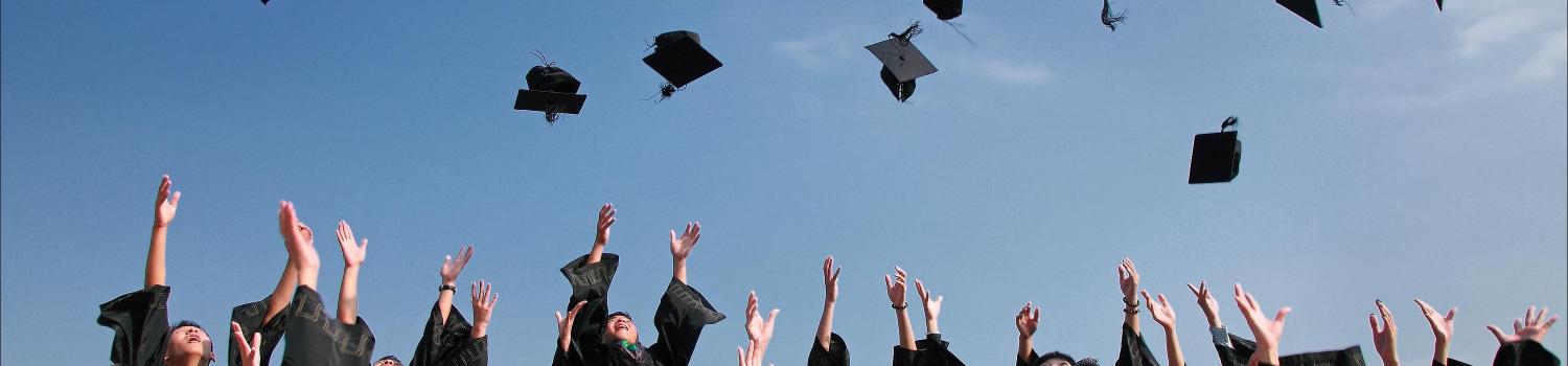 picture of people throwing hats at graduation