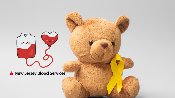 Image of stuffed bear toy with a golden yellow ribbon for Childhood Cancer Awareness Month on it. On the left there is a vector illustration of a blood bag connected to a heart shape filled with blood with smiley faces on both, and below that is the New Jersey Blood Services logo.